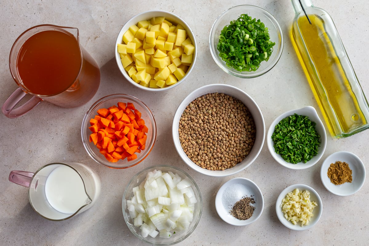 ingredients needed to make lentil soup including dried lentils, carrots, onion, potato, spices, oil, etc