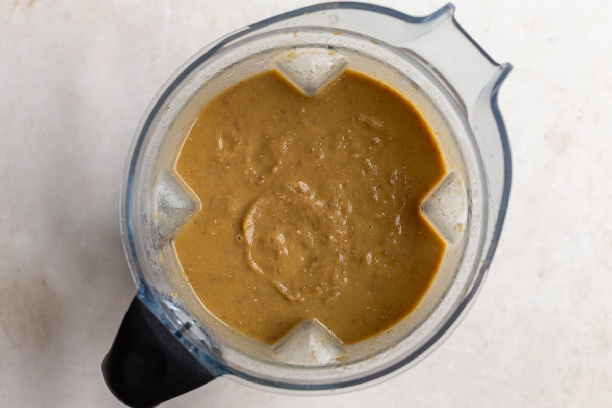 creamy lentil soup that's been blended up still inside of the blender