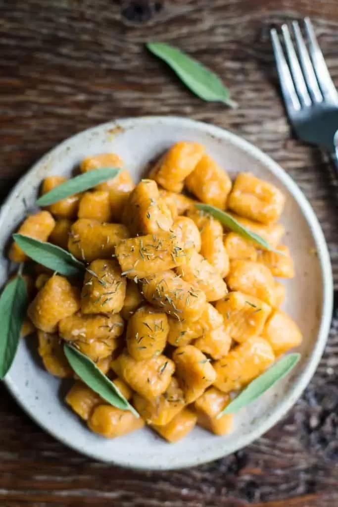 plate of sweet potato gnocchi on a wood table