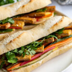 Tofu Banh Mi sandwich on a white plate.
