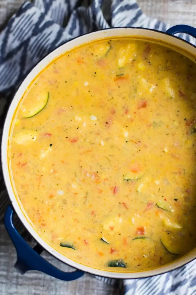 top down shot of a large enameled pot filled with vegan corn chowder