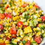 Grilled corn salad in a white serving bowl.