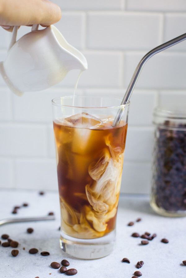 ice coffee with cream being poured in