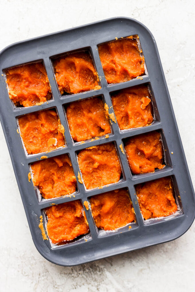 Pumpkin puree added to an ice cube tray.