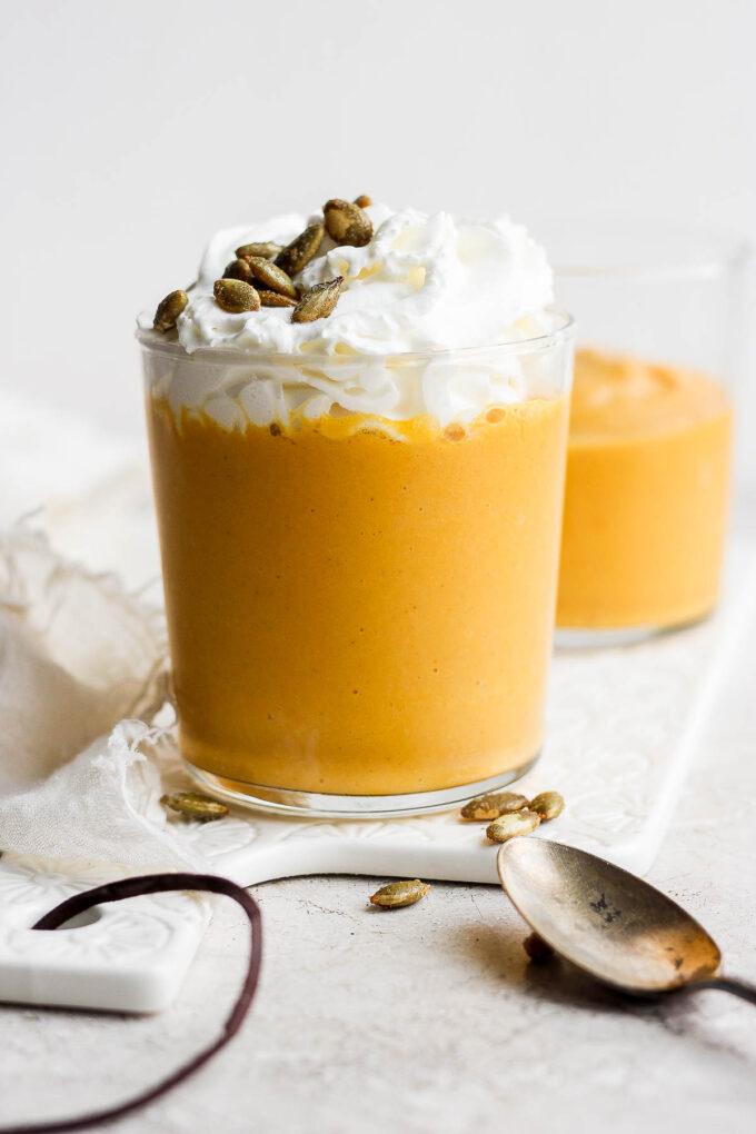 Orange smoothie topped with whipped cream.