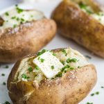 baked potato topped with pad of butter and chives
