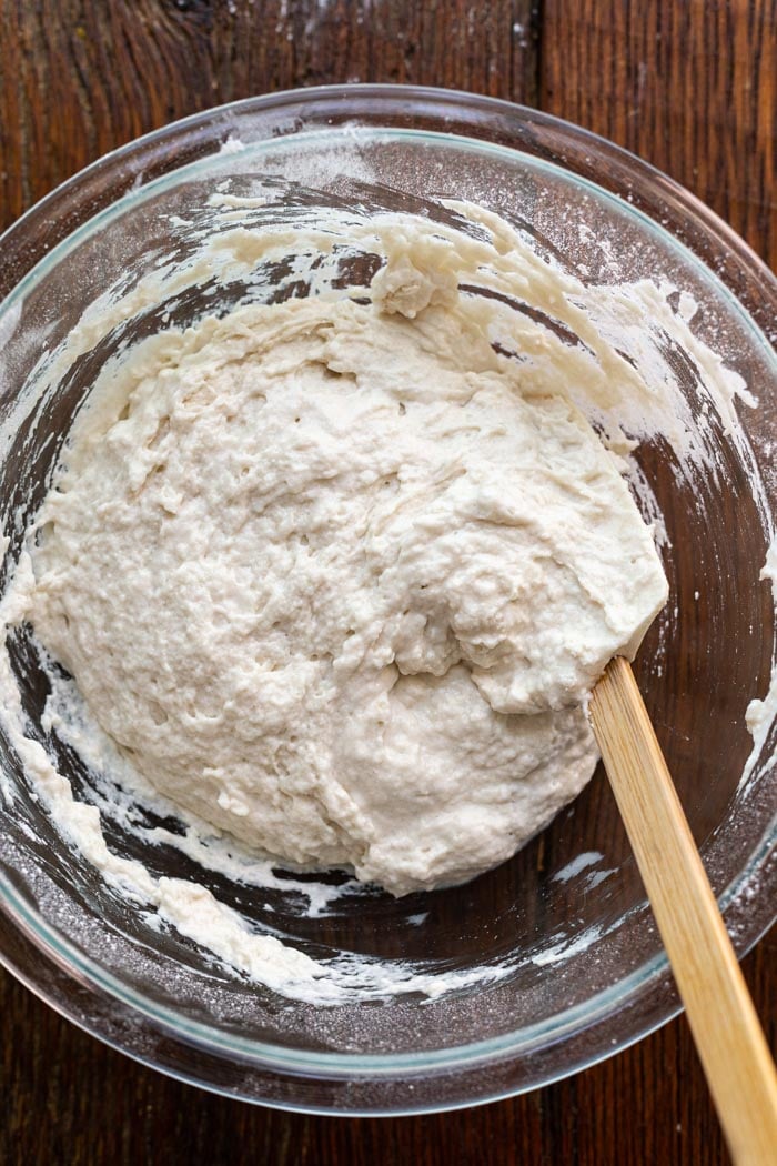 large bowl with dough in it sitting on a wooden table