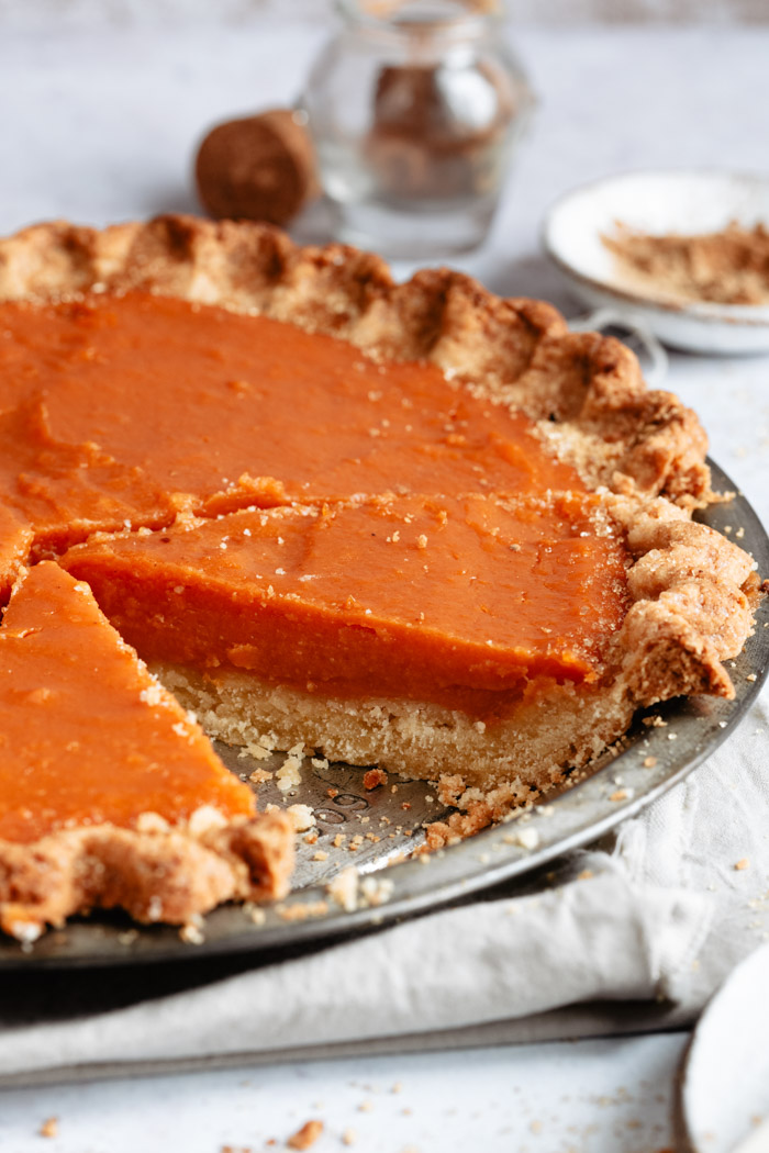 side shot of a sweet potato pie with a slice taken out 