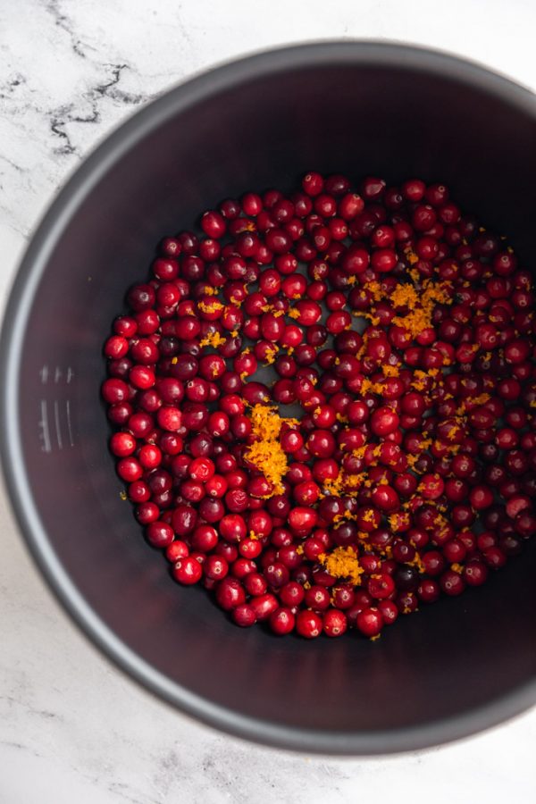 cranberries and orange zest in the pot of a pressure cooker