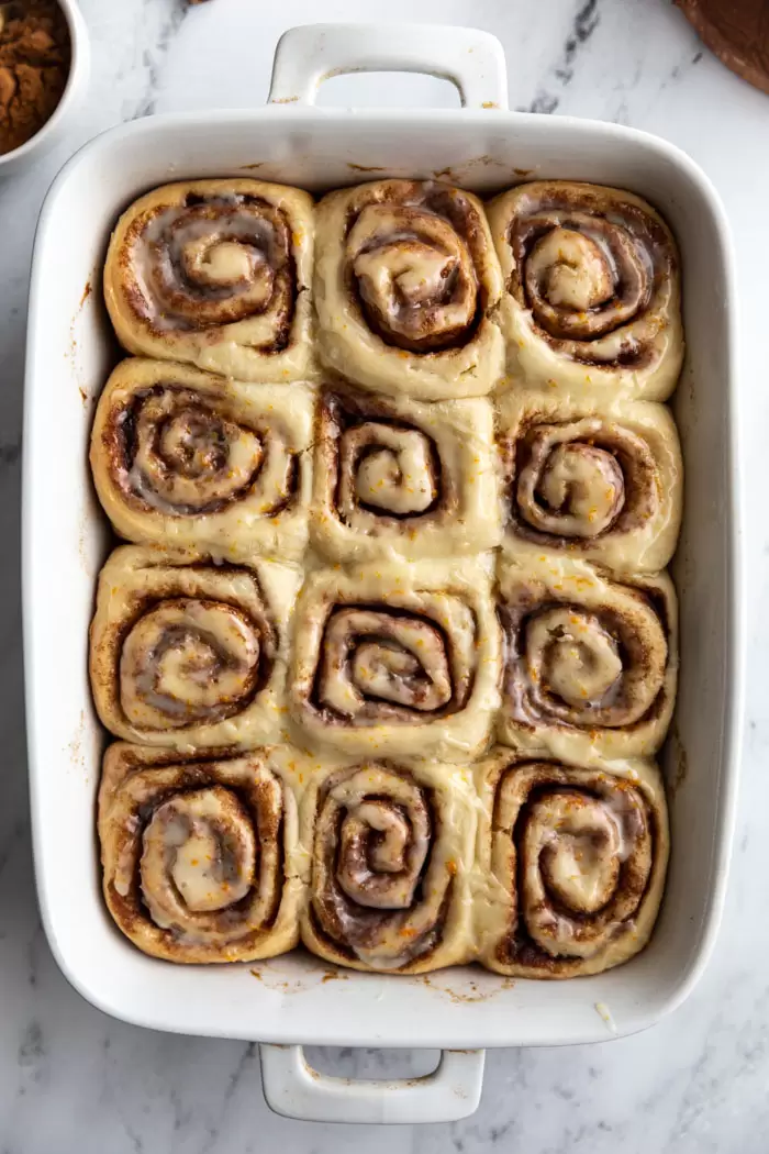 vegan cinnamon rolls iced in a baking tray