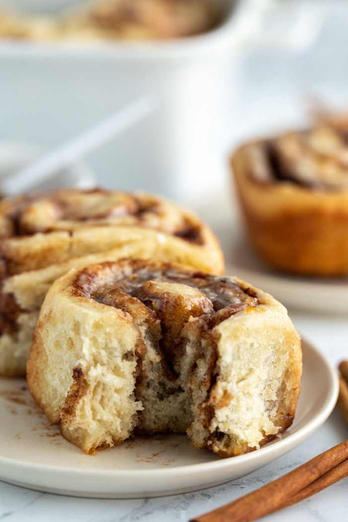 cinnamon roll on a plate with a bite taken out