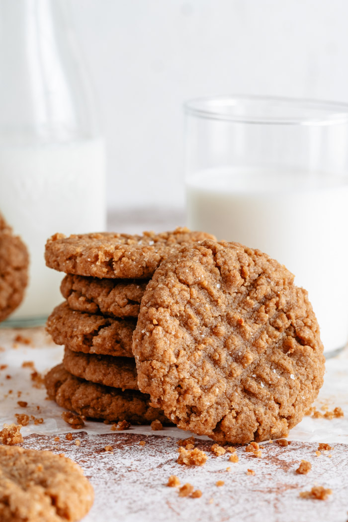 stack of vegan peanut butter cookies next to a glass of milk