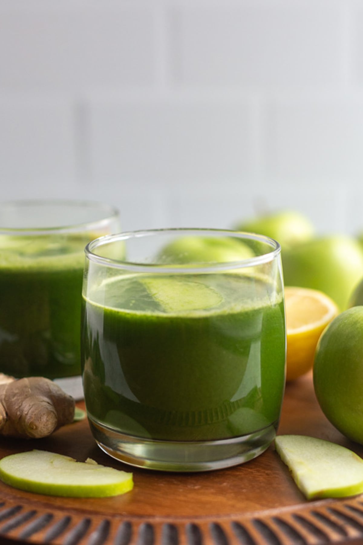 green juice in a small glass with another glass in the background