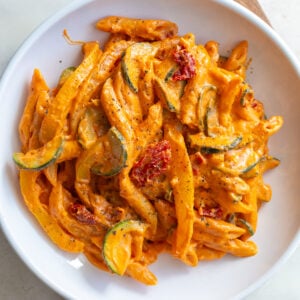 Creamy tomato pasta served in a white bowl.