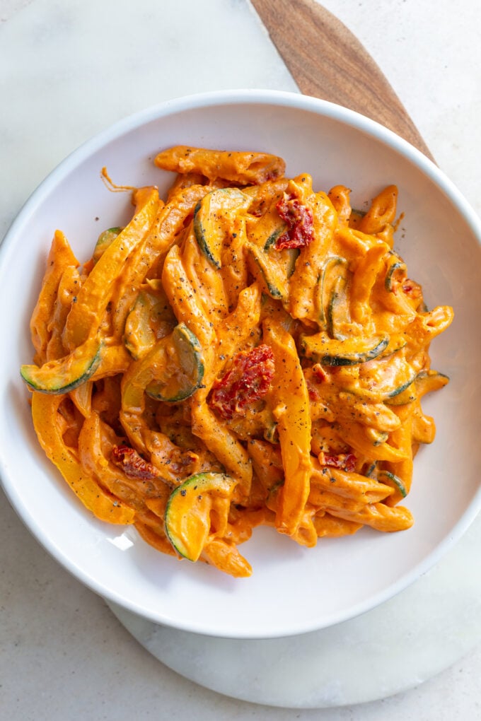 Creamy tomato pasta served in a white bowl.