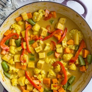 tofu coconut curry in a large skillet with a napkin in the corner