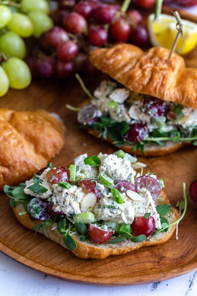 croissant cortado por la mitad y cubierto con micro verde y la ensalada de "pollo" de tofu con uvas"chicken" salad with grapes