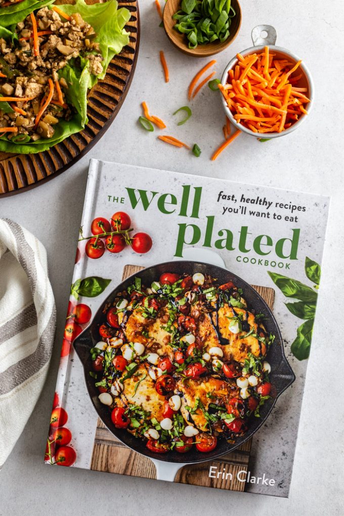 picture of the Well Plated Cookbook with carrots, lettuce wraps, and green onion in the corner