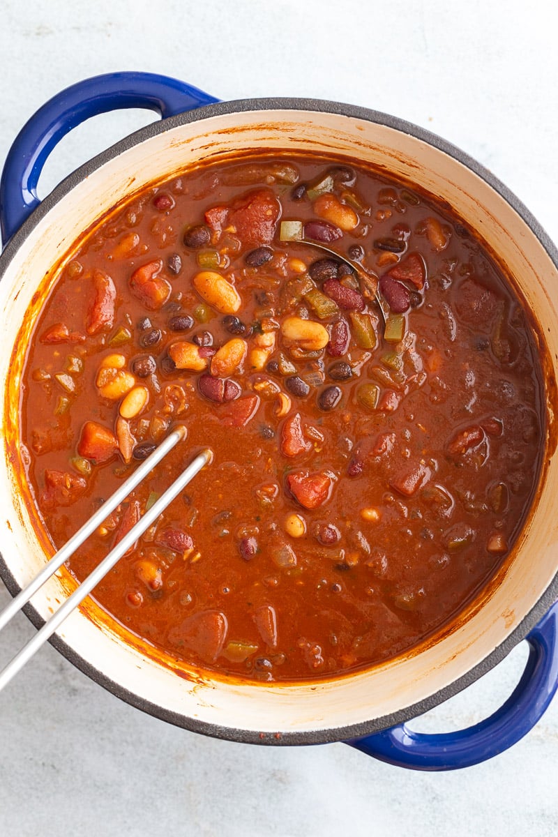 Stirring beans, tomatoes and broth in a large pot.