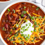 Vegan chili topped with sour cream and shredded cheese.
