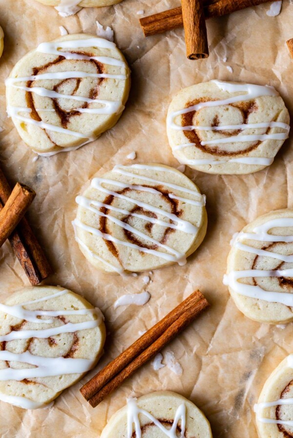 top down shot of cinnamon roll sugar cookies on parchment paper and drizzled with frosting
