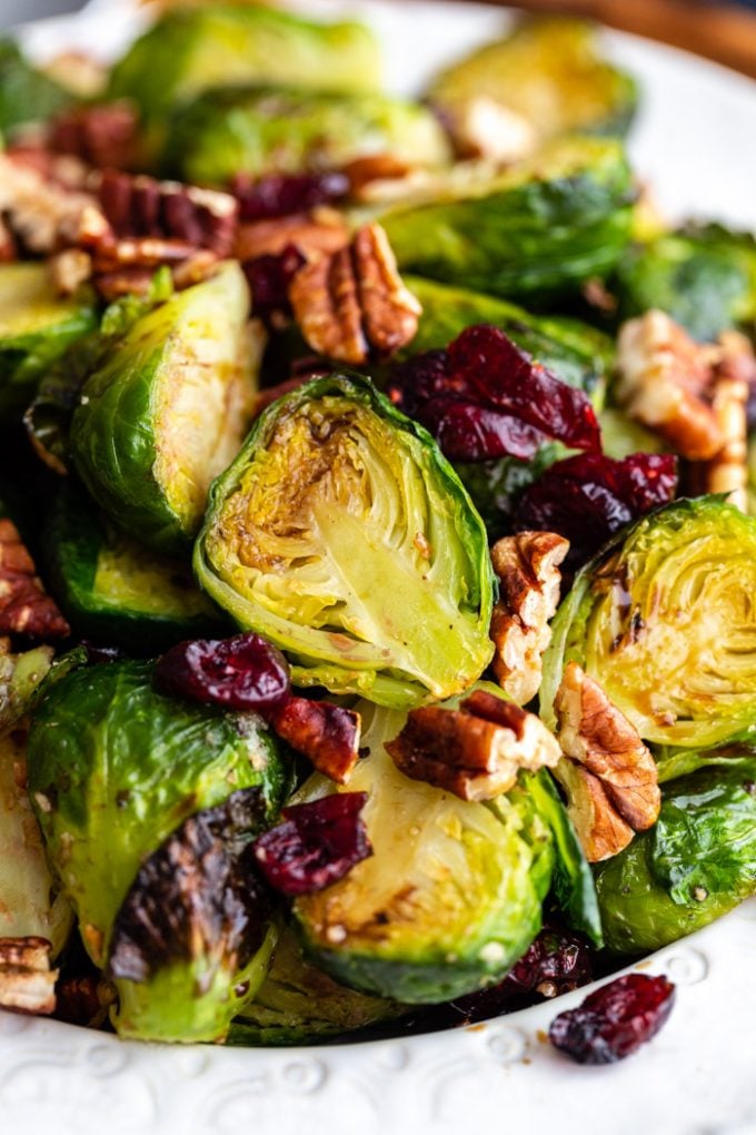 bowl full of roasted brussels sprouts mixed with dried cranberries and pecans