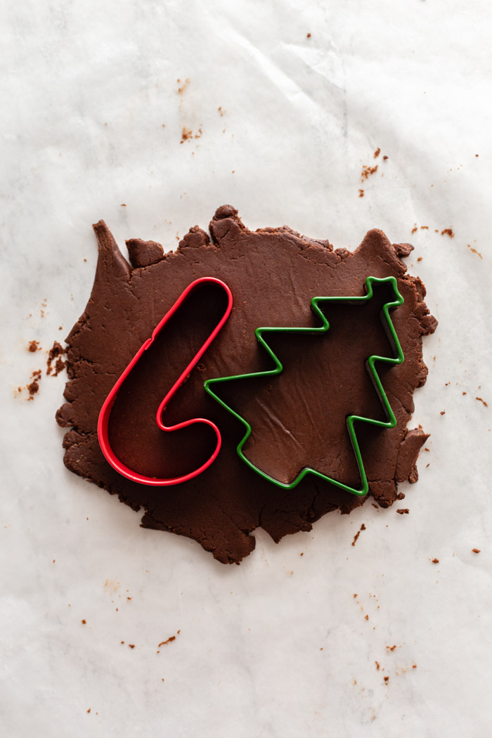 chocolate cookie dough rolled out with 2 cookie cutters sitting on top