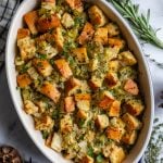 casserole dish filled with a simple vegan stuffing recipe topped with fresh herbs