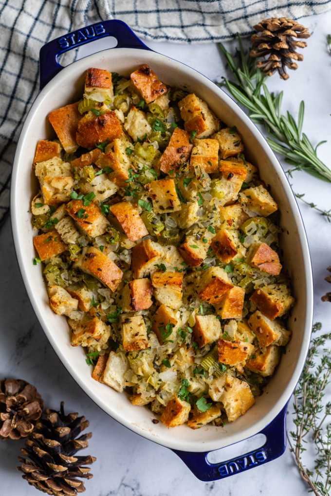 casserole dish filled with a simple vegan stuffing recipe topped with fresh herbs