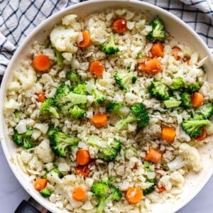 skillet with cauliflower fried rice that has broccoli and carrots in it