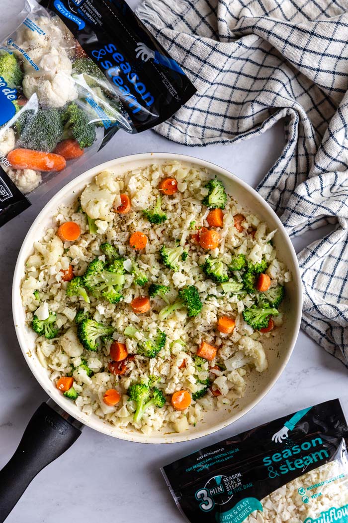 skillet with cauliflower fried rice that has broccoli and carrots in it