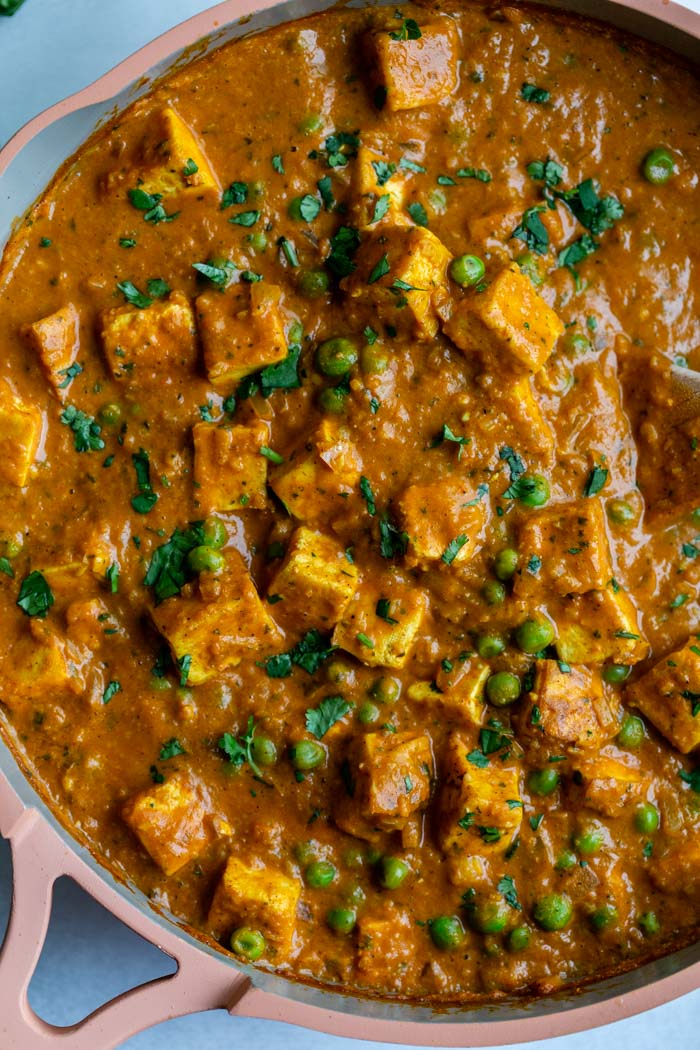 tikka masala topped with peas and fresh cilantro