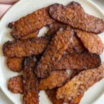 tempeh bacon strips stacked up on a plate