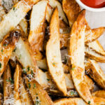 air fryer potato wedges topped with parsley and parmesan