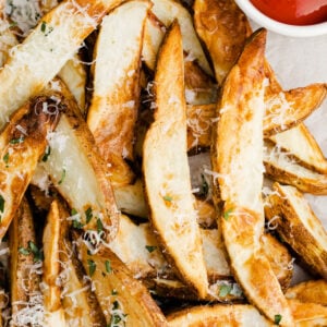 air fryer potato wedges topped with parsley and parmesan