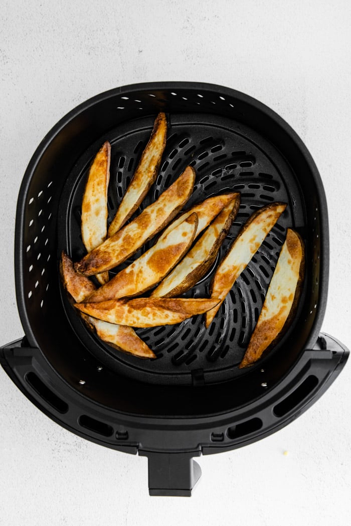 crispy potato wedges in an air fryer basket