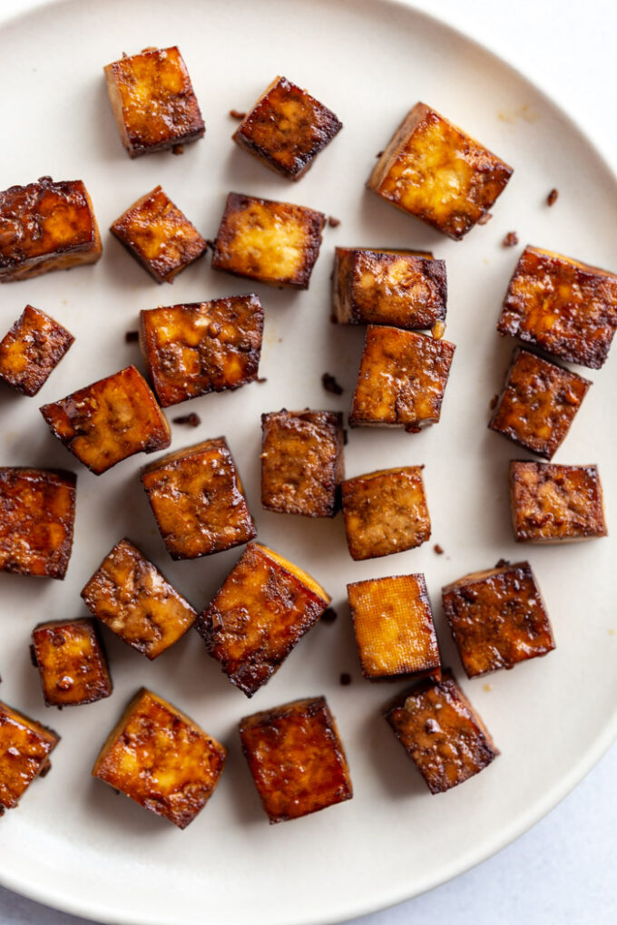 crispy brown tofu cubes on a white plate