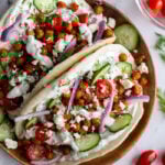 gyro made with crispy chickeas topped with red onion and feta cheese. on a wood plate