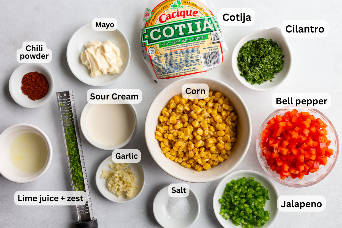 ingredients needed to make mexican street corn salad: corn, crema, cotija, bell pepper, cilantro, lime juice and zest, salt, chili powder, and jalapeno