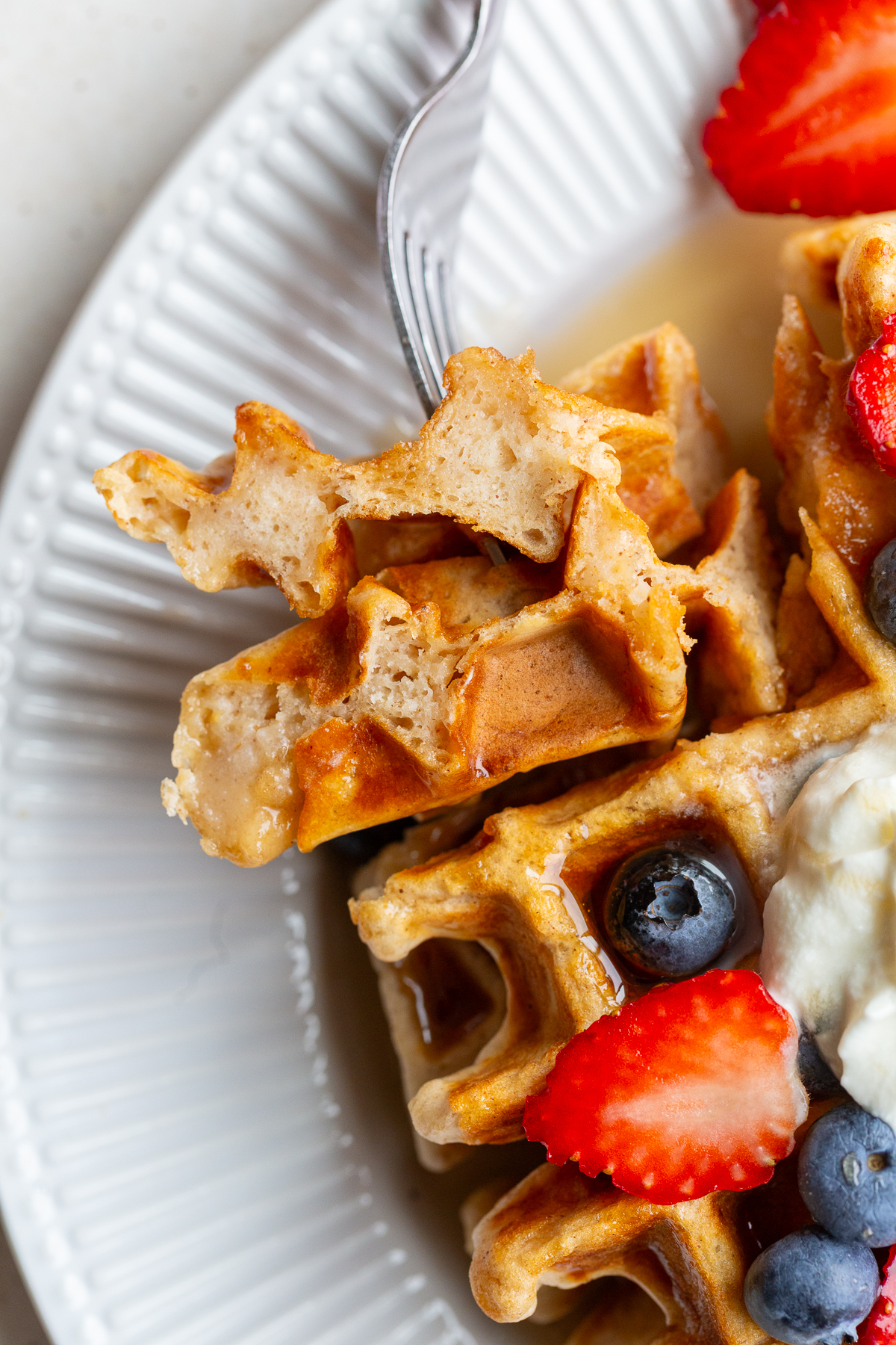Vegan waffle on a fork with berries.