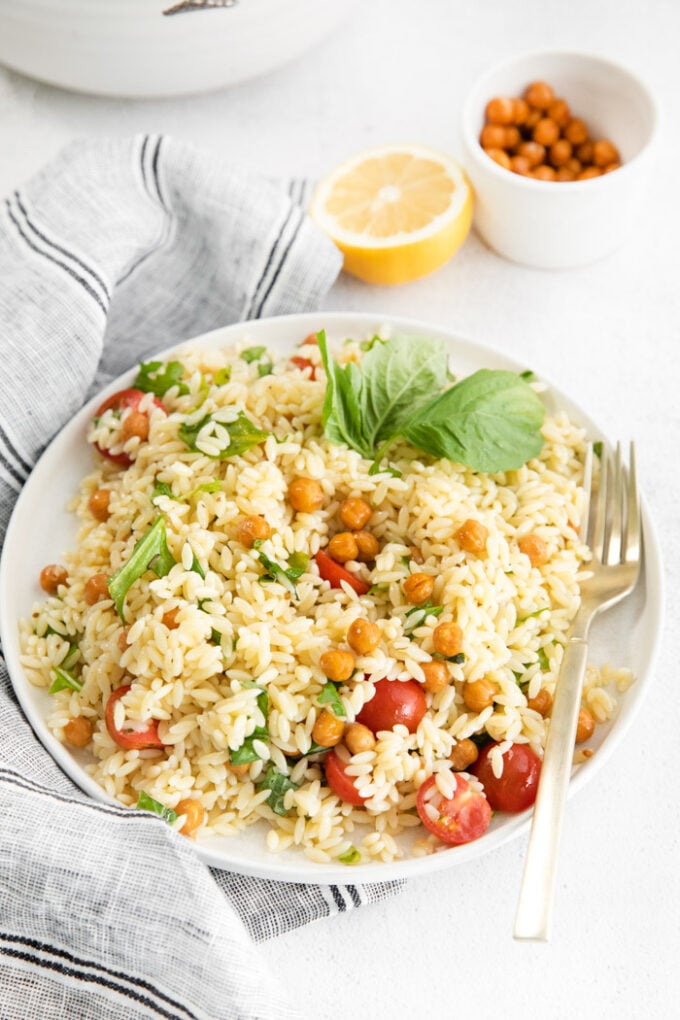 lemon orzo salad served on a white dinner plate with a fork