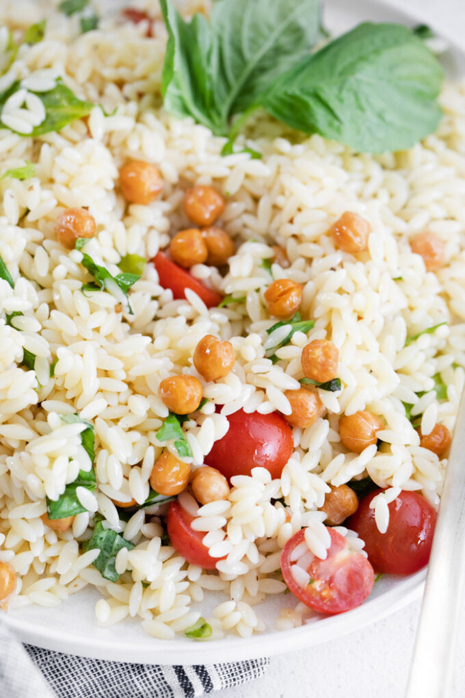 orzo pasta salad topped with chickpeas and cherry tomatoes