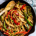 soy curls fajitas with soy curls and sauteed onion and green + red bell pepper in a large cast iron skillet