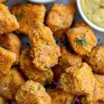 crispy tofu nuggets on a tray with ketchup and mustard in the corner of the shot