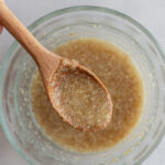 flax egg in a small bowl with a wooden spoon in it