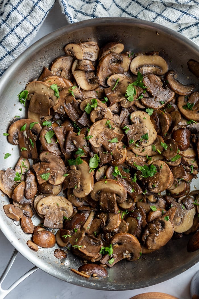 baby Bella mushrooms sautéing in a large skillet