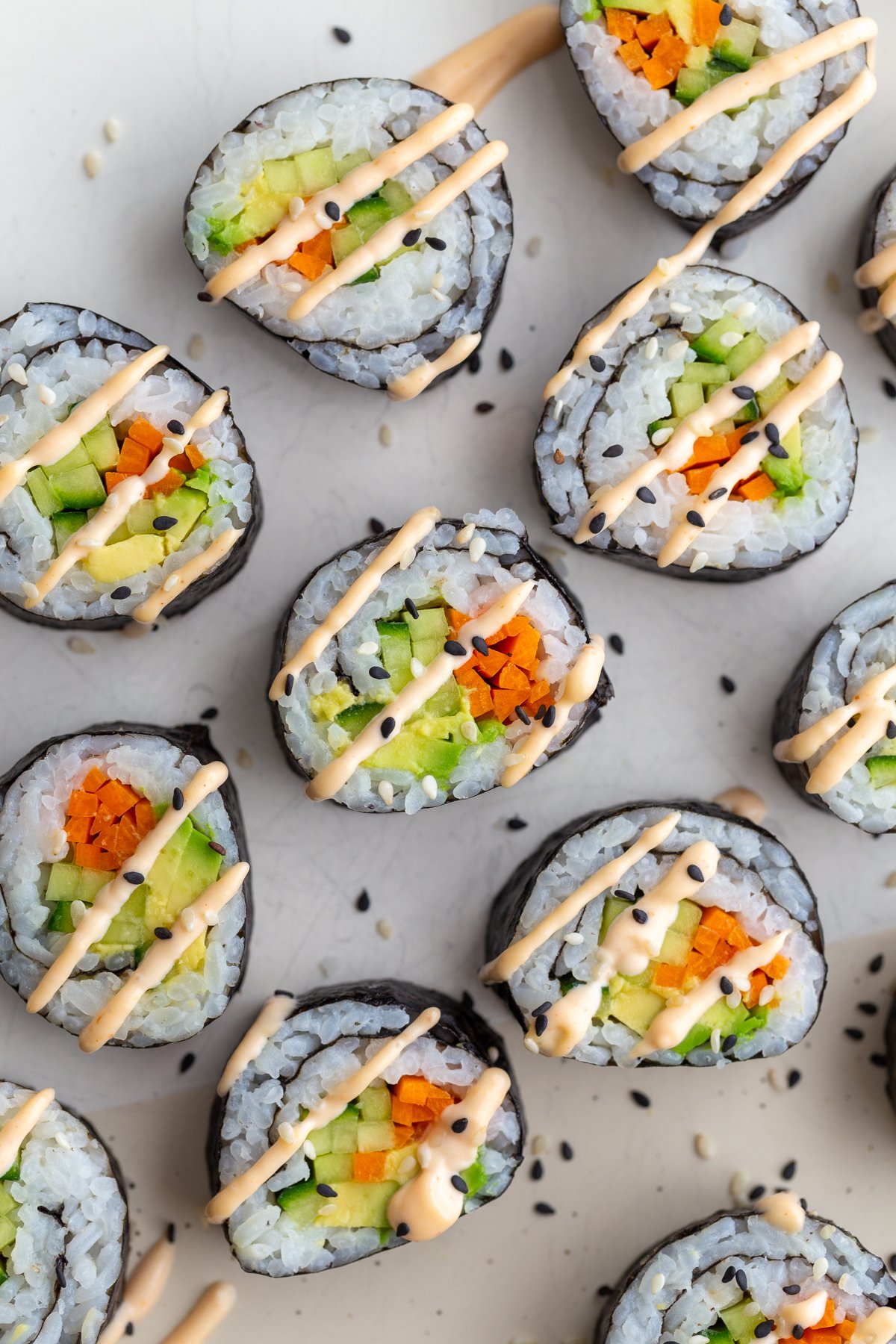 Cucumber rolls with pickled carrots, cucumber and avocado sprinkled with sesame seeds.