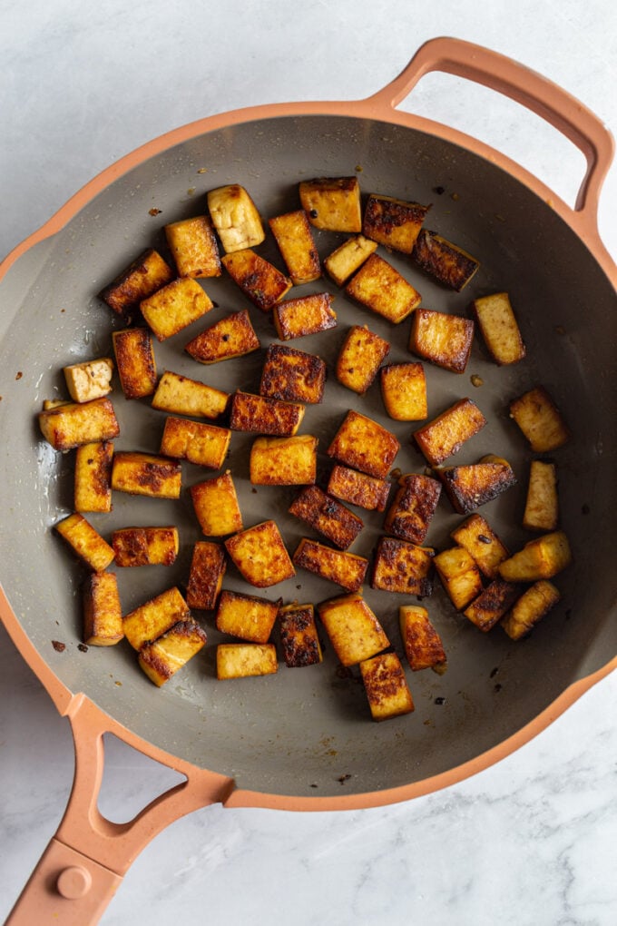 marinated tofu cooking in a large skillet