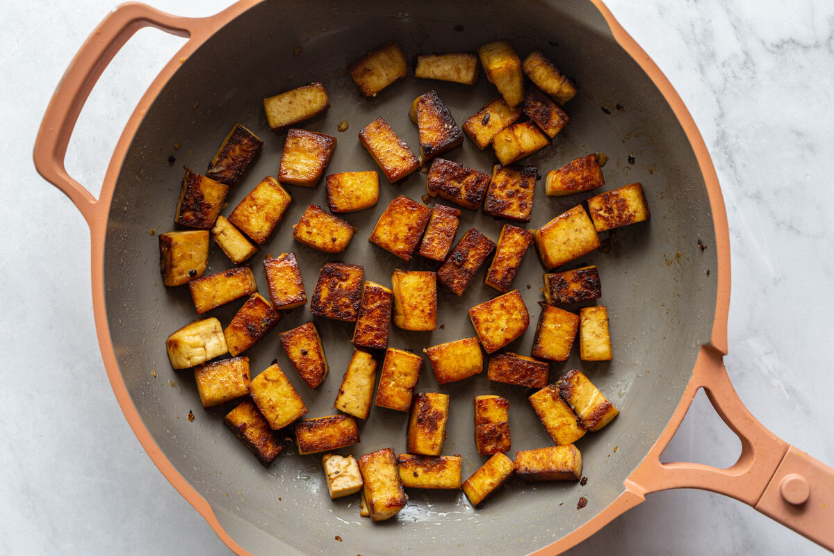 marinated tofu cooking in a large skillet