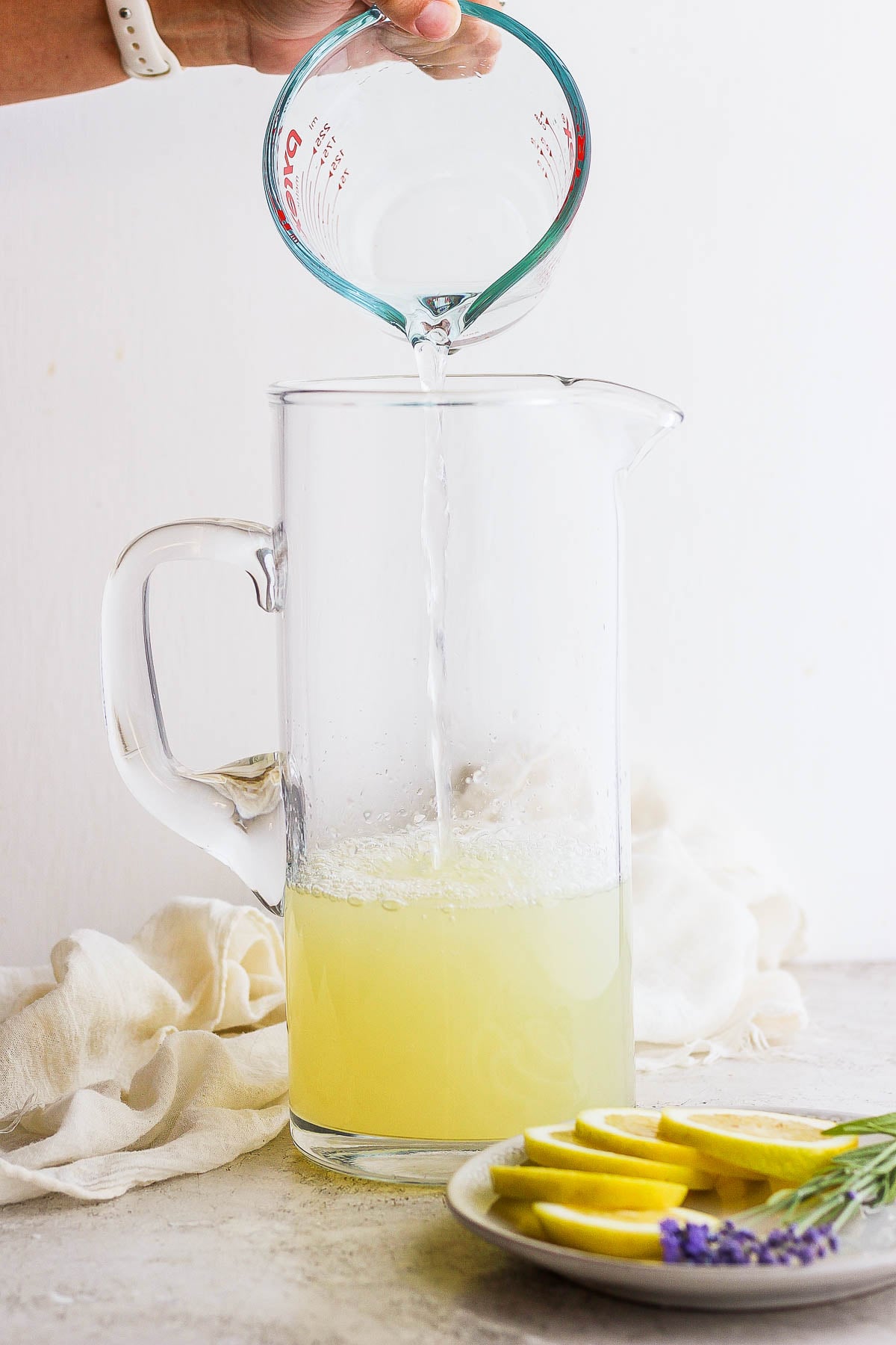 water and lemon juice being mixed together in a tall pitcher